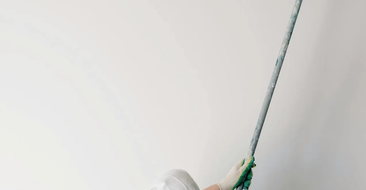Rolling a fresh coat of paint onto a smooth interior wall.